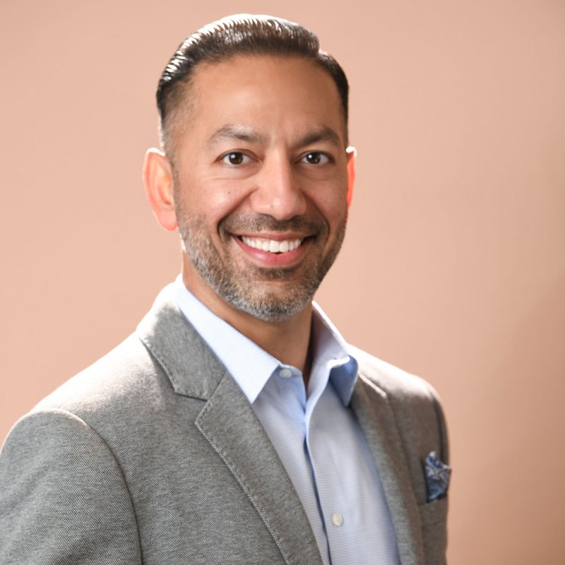 Geetesh Kapoor, smiling, in a grey jacket
