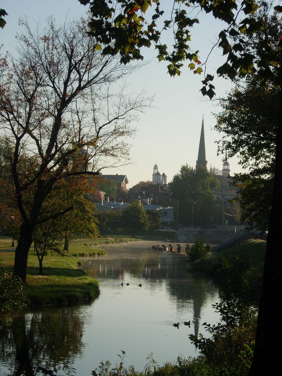 The spires of Frederick reflected in the water at Baker Park